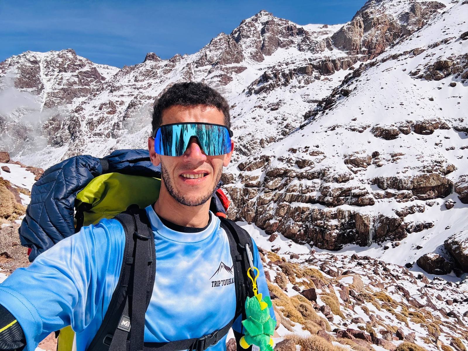 Saïd, Kasbah Oasis mountain guide, high on Mount Toubkal with the High Atlas peaks behind him