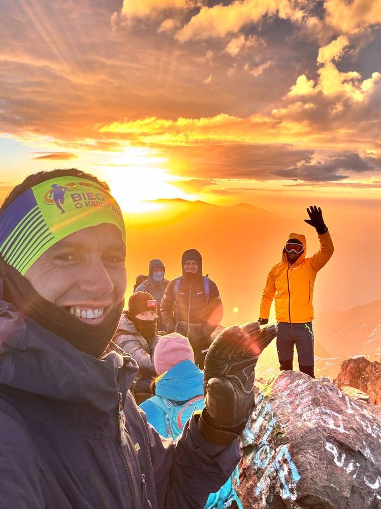 Saïd celebrating with fellow trekkers at sunrise on the summit ridge